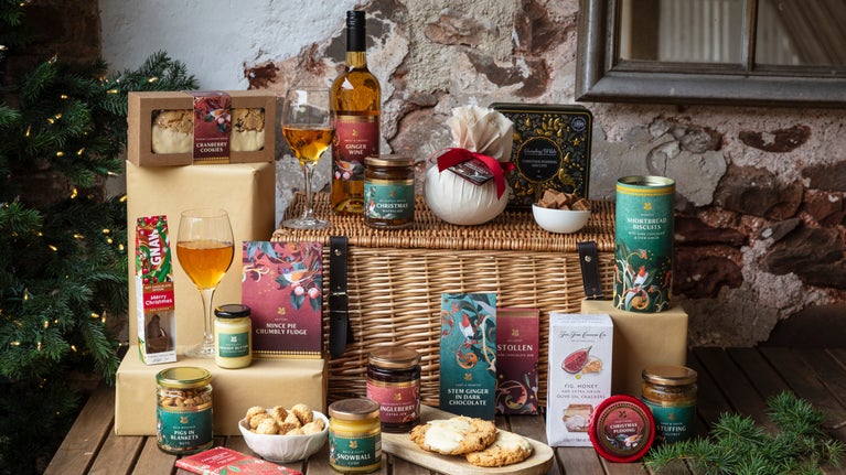 A selection of Christmas food and drink products, arranged around a hamper